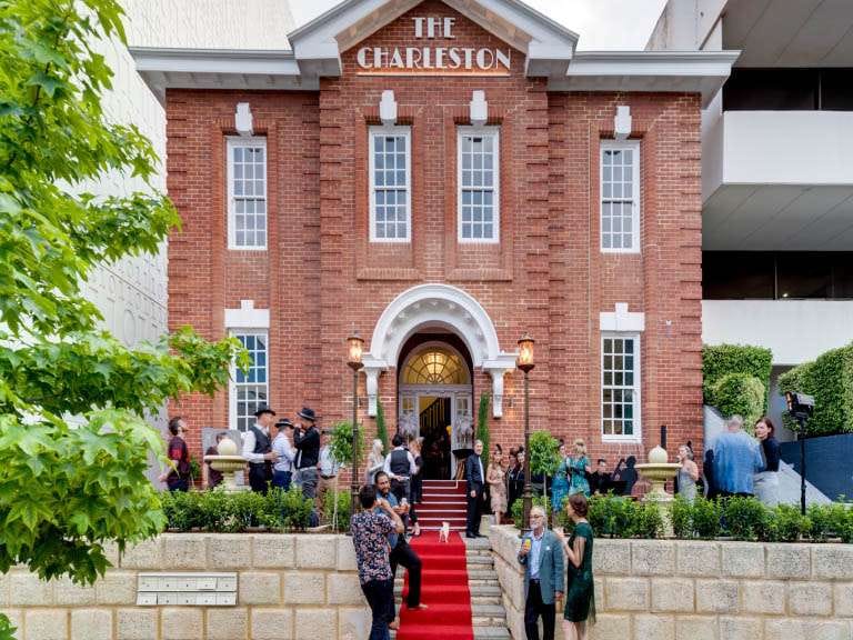 The Charleston: historic red-brick venue hosting diverse, stylish social event with modern urban backdrop.